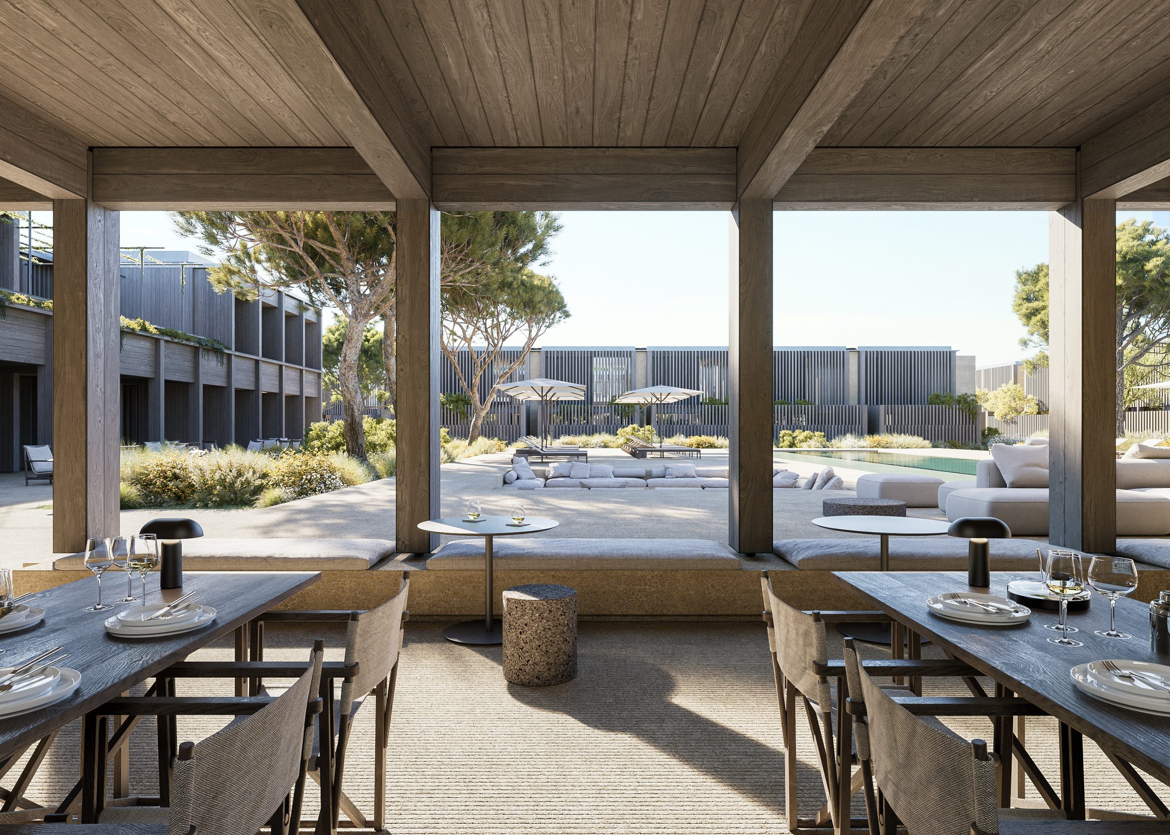 A view from the all-day cafe across the pool courtyard, framed by the timber colonnade and umbrella pines.