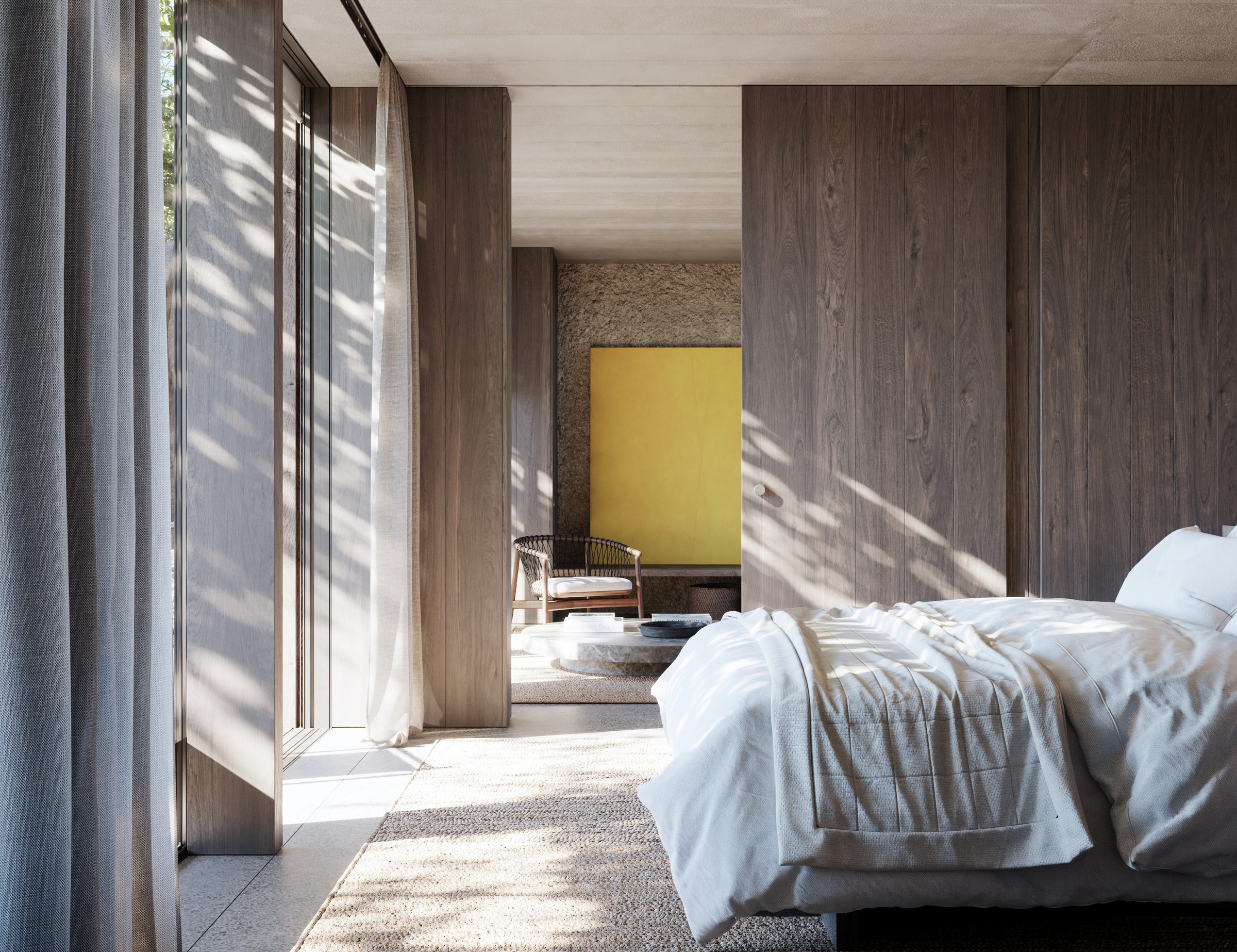 A bedroom in a suite at the AMAIA hotel — timber walls, jute rug, linen bedding, and morning light through sheer curtains.